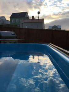 斯蒂克松鲁姆Garður restored house的蓝色的游泳池,映衬着天空