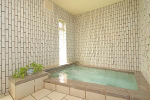 山中湖村Pension Aroma Herbs Le Lagon的铺有瓷砖的客房内设有一个按摩浴缸。