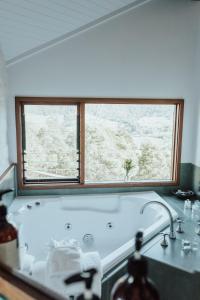 希尔斯维尔袋鼠岭度假山林小屋的带浴缸的浴室和窗户