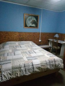 瓦尔帕莱索阿曼多旅馆 的卧室配有一张床,墙上挂有绘画作品