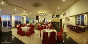 邦美蜀西贡帮美酒店的一间设有红色椅子和桌子的餐厅