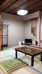 金泽金马醋民宿旅馆的客厅配有木桌和2个地毯