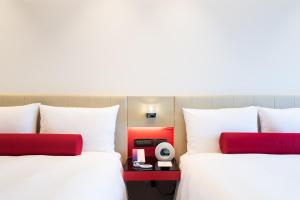 台北台北凯达大饭店的两张带白色和红色枕头的床