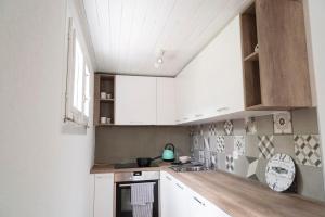 Ponto ValentinoModern charme studio in Chalet的厨房配有白色橱柜和水槽
