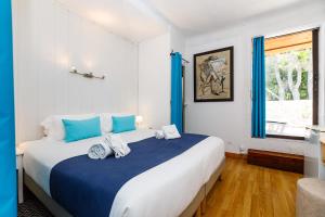 穆然里斯德莫酒店的一间卧室配有一张带蓝色枕头的大床