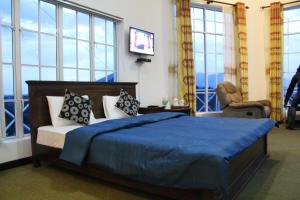 努沃勒埃利耶Dewdrops at Lake Gregory的一间卧室配有一张带蓝色床单和窗户的床。