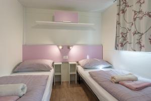 比奥格勒·纳·莫鲁Camping Park Soline - Mendula I Mobile Home的配有粉红色和白色墙壁的客房内的两张床