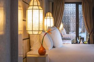 马拉喀什Dar Kandi的一间卧室配有一张带灯和窗户的床