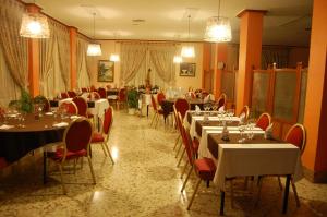 卡兰达巴尔法丰酒店的一间设有白色桌子和红色椅子及桌子的餐厅