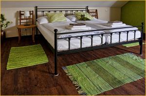 克拉托维Statek česká lípa Myslovice的卧室配有一张床铺,地板上铺有2个地毯。