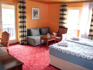 蒂蒂湖-新城诺伊施塔特霍夫酒店的一间卧室配有一张床、一张沙发和一张桌子