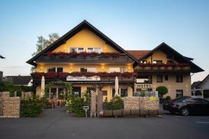 赫费尔霍夫Hotel Garni Zum Grünen Baum的一座建筑前方鲜花盛开的酒店