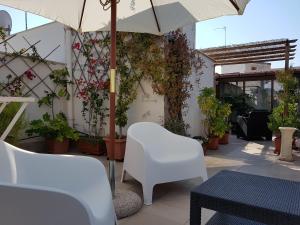 特拉尼托伦特安蒂科住宿加早餐旅馆的庭院配有白色椅子和遮阳伞。
