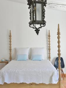 卡西斯Mas du Perthus的一间卧室配有一张带白色床单和吊灯的床。
