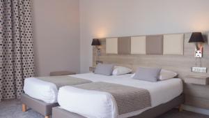 安菲翁·莱斯·班恩斯德斯普林西斯酒店的一间卧室配有两张带白色床单的床