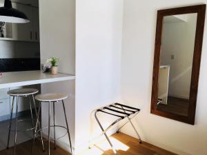 贝伦埃斯科巴Studio的厨房配有2张凳子和墙上的镜子