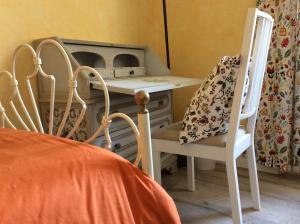 佩鲁贾Le Camere di Casa Cassandra的一间卧室配有书桌、两把椅子和一张床