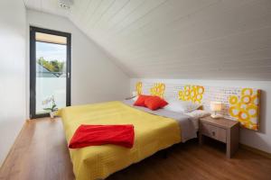 德布吉Domki Morski Raj的一间卧室配有一张大床,提供黄色和红色枕头