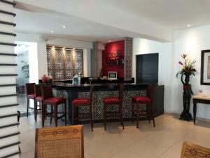 梅里达玛丽亚何塞酒店的厨房设有红色墙壁和凳子的酒吧