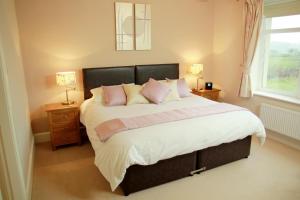 康福斯凯普尔恩乌雷酒店的卧室配有一张带粉红色枕头的大床