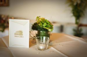 戈赫利特耶斯酒店的坐在桌子上植物旁边的一杯水