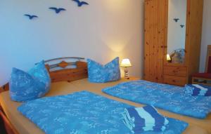 格拉尔-米里茨Ferienwohnung Möwe的一间卧室配有两张带蓝色床单的床,墙上有鸟儿