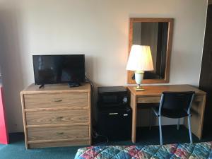 柯克斯维尔乡村汽车旅馆的一间卧室配有一张书桌、一台电视和一个梳妆台