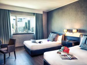 圣地亚哥圣地亚哥中心美居酒店的酒店客房带两张床、椅子和窗户