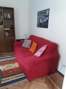 奥斯塔Appartamento Fantasia CIR Aosta 0241的客厅里配有红色沙发,配有枕头