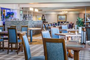 BlackwaterfootKinloch Hotel, Isle of Arran的一间带桌椅的餐厅和一间酒吧