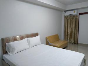 曼谷Roseate Bangkok Hotel的卧室配有白色的床和椅子