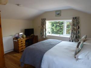 滨海萨顿Manor Farm Stay的卧室配有白色的床和窗户。