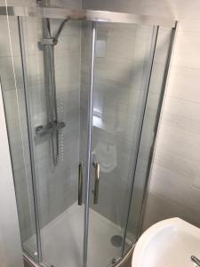 卡纳芬Cozy Snowdonia Chalet的卫生间旁的玻璃门淋浴