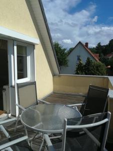 宾茨FerienWohnung Gebhardt的阳台上的玻璃桌子和椅子