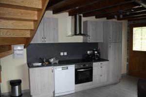 Axiatla forge d'andribet的厨房配有白色橱柜和白色洗碗机。