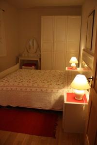 卡尔达罗Haus Rogger的一间卧室配有一张带两盏灯和镜子的床