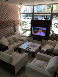 阿达纳Asus Palmiye Otel的客厅配有白色沙发和平面电视。