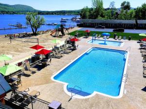 乔治湖斯科蒂湖滨度假酒店的湖畔带椅子和遮阳伞的游泳池