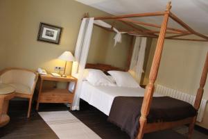 昆卡昆卡酒店的一间卧室配有一张天蓬床和一张带电话的书桌