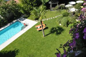 拉纳Hotel Verena的棕榈树和长凳的院子内的游泳池