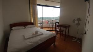 哈恩Hotel Santorini的一间卧室配有一张床、一张桌子和一个窗户。