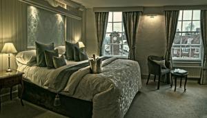 罗伯茨布里奇乔治旅店 的一间卧室设有一张大床和一个窗户。