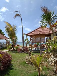 珀尼达岛The Umah Prahu的棕榈树和大海的度假村