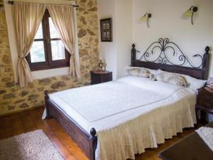 斯塔夫鲁波利To Archontiko Guesthouse Villa的一间卧室设有一张大床和一个窗户。
