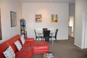 阿卡罗阿阿卡罗阿中央公寓的客厅配有红色的沙发和桌子