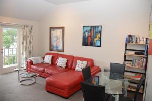 阿卡罗阿阿卡罗阿中央公寓的客厅配有红色的沙发和玻璃桌