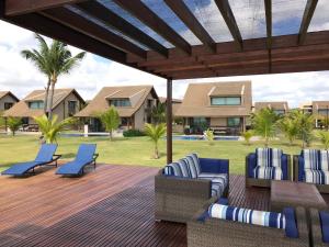 嘎林海斯港Charmoso Flat Nui Supreme - Térreo的一个带椅子的庭院和一个带棕榈树的甲板