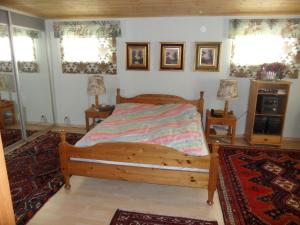 ArkelstorpSemestervilla vid sjö的一间卧室设有木床和2个窗户。