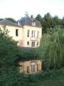 翁弗勒尔Chambres d'Hôtes Entre Deux Rives的水体中反射的旧房子