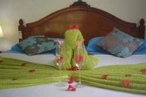 拉迪格岛绿竹小屋旅馆的身着绿色服装的人,站在床上,戴着酒杯